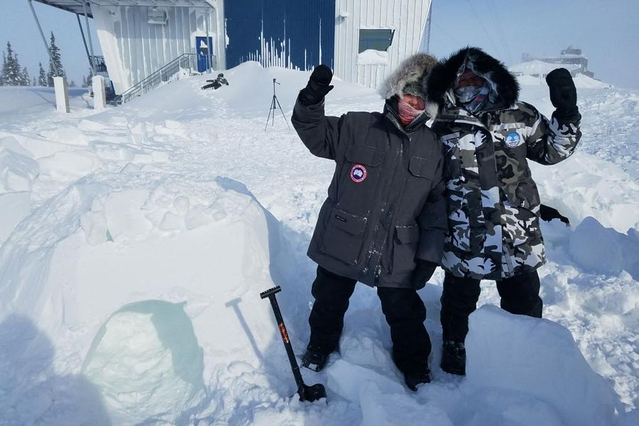 Two Agnes Scott study abroad co-leaders waving in a blizzard in Manitoba, Canada in 2017.
